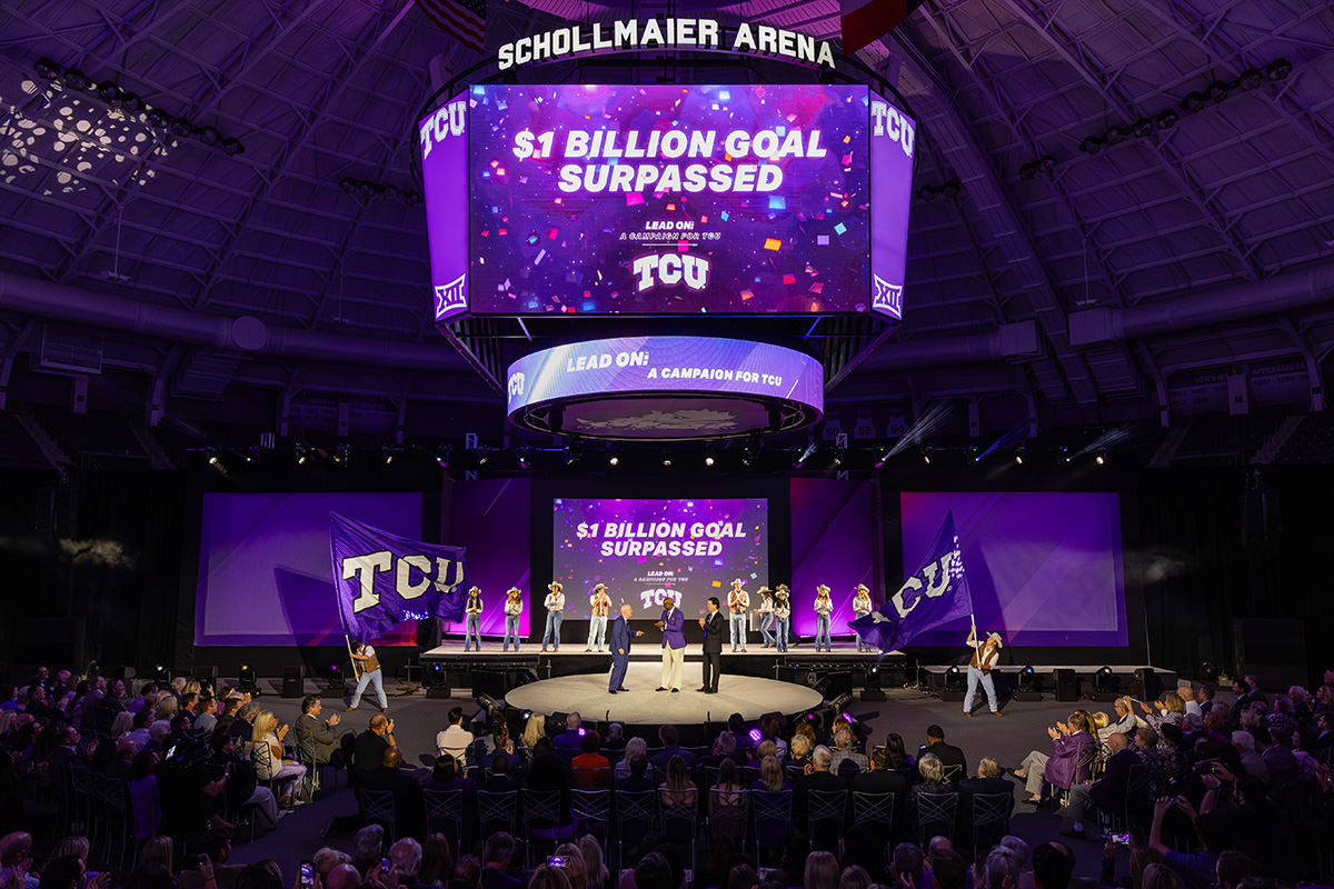 Chancellor Boschini, Ron Parker and Dee Kelly celebrate surpassing $1 billion goal on stage in Schollmaier Arena