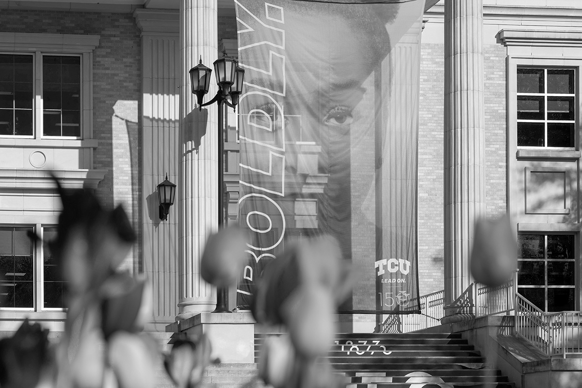 Close-up shot of Lead On banner hanging between columns of Mary Couts Burnett Library